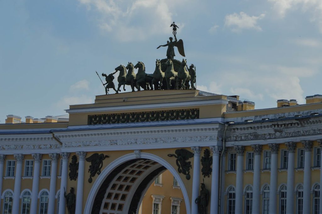 Close-up of the ornate Triumphal Arch with a majestic chariot sculpture under a clear sky.