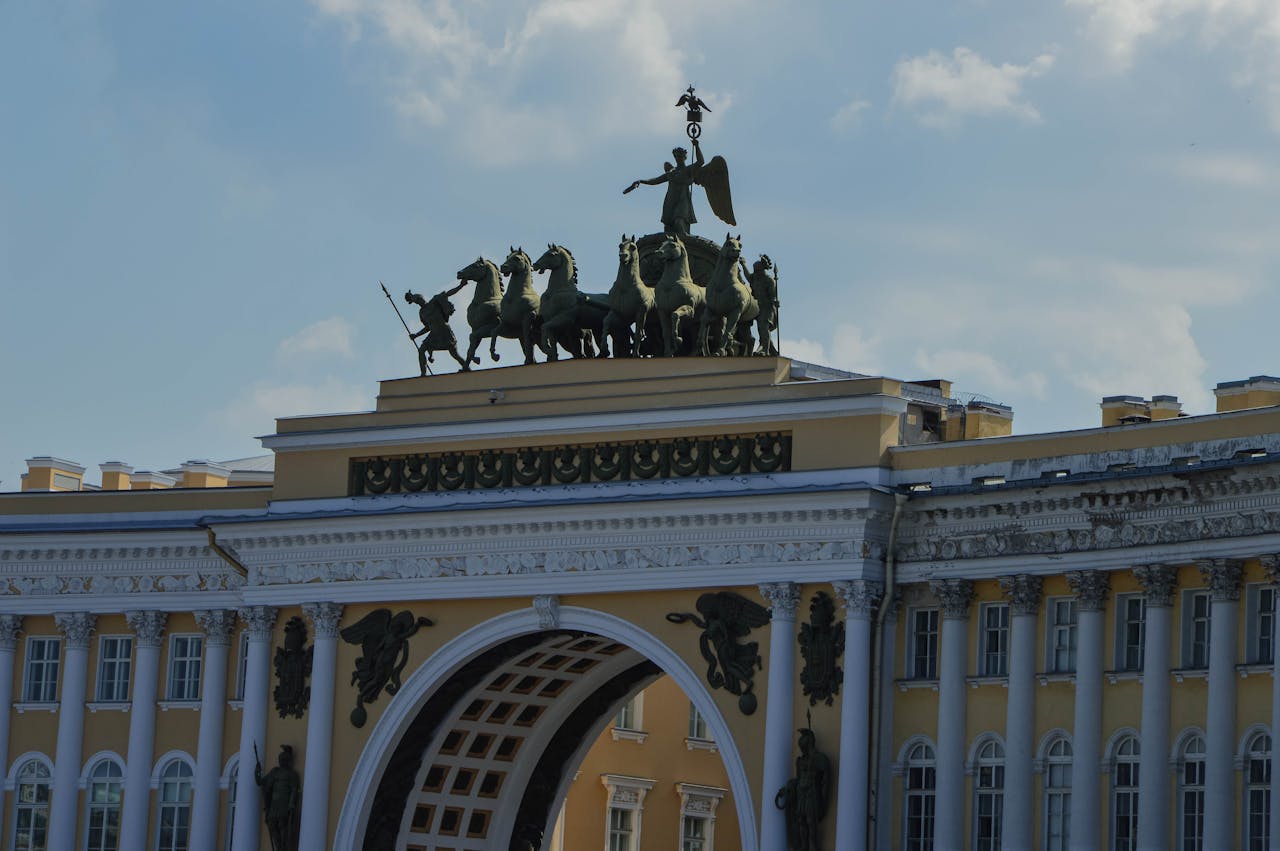 Close-up of the ornate Triumphal Arch with a majestic chariot sculpture under a clear sky.